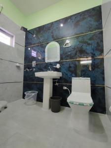 a bathroom with a white toilet and a sink at M2 lambardaar in Dehradun +10 photos