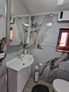 a bathroom with a sink and a marble wall at Apartment Blidinje, Ranch Mikulic in Blidinje +15 photos
