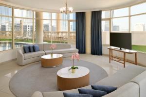 a living room with two couches and a tv at Roda Al Murooj Residences in Dubai