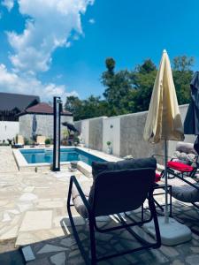a couple of chairs and an umbrella next to a pool at Apartmani Vukotić in Budva
