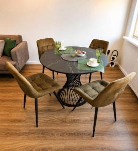 a dining table and chairs in a living room at Baltijos Apartamentai, Self check-in, free parking in Klaipėda