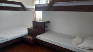 two bunk beds in a room withthritisthritisthritisthritisthritisthritisthritisthritisthritis at Casa Bahia Dive Resort in Mabini +1 photo