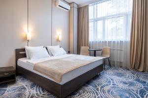 a hotel room with a bed and a window at Rush Inn Hotel in Astana