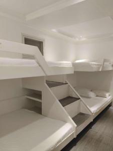 a white bunk room with white bunk beds at Casa Bahia Dive Resort in Mabini