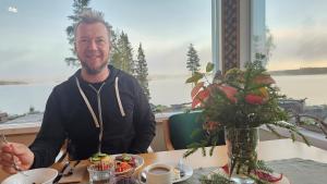 a man sitting at a table with a plate of food at Boutique Hotelli Kivennapa in Pieksä