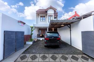 a car parked in the driveway of a house at Agni Homestay in Yogyakarta
