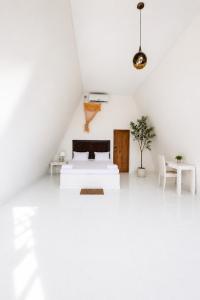 a white room with a bed and a table at Jungle safari inn in Udawalawe
