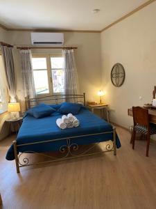 a bedroom with a blue bed with two towels at Sweet Suite in Mytilene