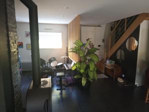 a living room with a plant and a staircase at Guest House Erdeven in Erdeven