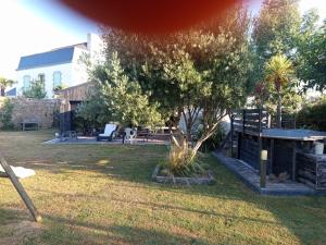 a yard with a tree and a house at Guest House Erdeven in Erdeven