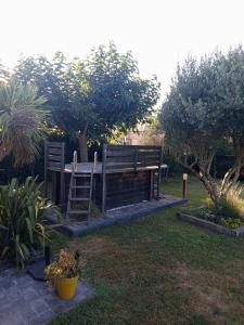 a garden with two wooden chairs and a table at Guest House Erdeven in Erdeven
