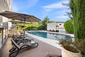 a swimming pool with lounge chairs and an umbrella at Modern Rooms Villa Oasiss by Istrabook in Pula