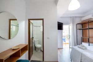 a bedroom with a bed and a mirror and a bathroom at Sunny Hotel in Sarandë +154 photos