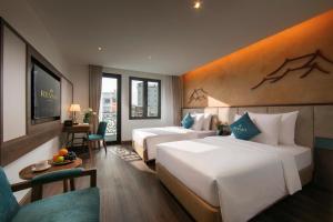 a hotel room with two beds and a television at Reviah Hotel in Hanoi