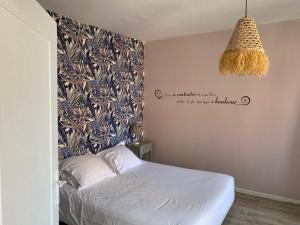 a bedroom with a bed and a chandelier at Gites de la Haute Ville in Boulogne-sur-Mer