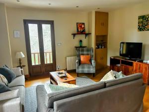 a living room with a couch and a tv at La Casa deMercadillo in Liérganes