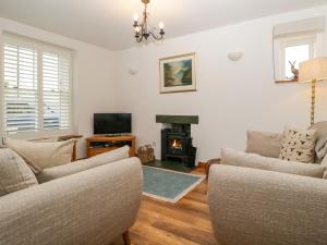 a living room with two couches and a fireplace at Capella Cottage in Keswick