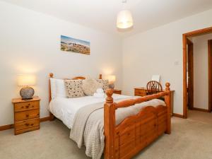 a bedroom with a wooden bed and a wooden dresser at Capella Cottage in Keswick