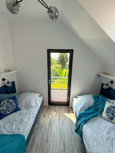two beds in a room with a window at Domki Nord Star in Władysławowo