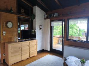 a living room with a tv and a large window at Ferienhaus Schallerhof in Kupferberg +4 photos