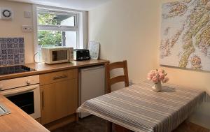 a small kitchen with a table and a microwave at Rubybank Bothy, overlooking Loch Fyne in Strachur