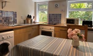 a kitchen with a table with a vase of flowers on it at Rubybank Bothy, overlooking Loch Fyne in Strachur +19 photos