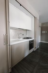 a kitchen with white cabinets and a sink and a stove at Appartamento in Piazza a Bevagna in Bevagna