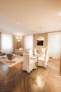 a living room with a glass table and white chairs at Appartamento in Piazza a Bevagna in Bevagna