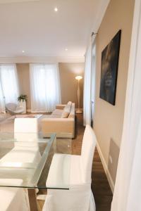 a living room with a glass table and white furniture at Appartamento in Piazza a Bevagna in Bevagna