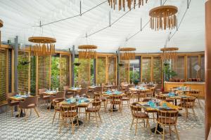 a dining room with tables and chairs and chandeliers at Park Inn by Radisson Bucharest Hotel & Residence in Bucharest
