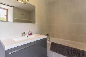 a bathroom with a sink and a bath tub at Valfermet 5 personnes in Mauvilly +18 photos