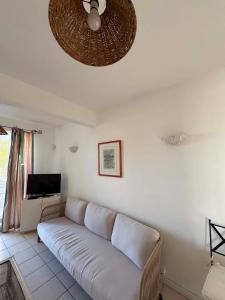 a white couch in a living room with a ceiling at Appartement hibiscus in Grand-Baie
