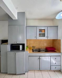 a kitchen with white cabinets and a sink at Appartement hibiscus in Grand-Baie