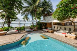 an outdoor swimming pool with lounge chairs and a resort at Muang Samui Spa Resort in Chaweng