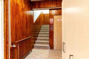 a hallway with stairs in a building with wooden walls at Penzión Stálica in Bojnice