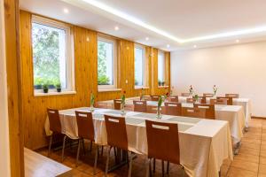 a conference room with tables and chairs and windows at Penzión Stálica in Bojnice