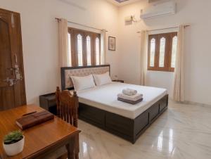 a bedroom with a large bed and a table at Prasads Homestay in Gaya
