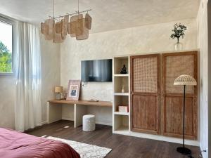 a bedroom with a bed and a desk and a television at Bulle de détente - Proche Disney in Villiers-sur-Morin