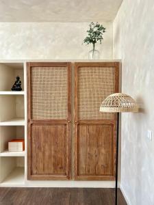 two wooden doors in a room with a lamp at Bulle de détente - Proche Disney in Villiers-sur-Morin