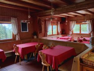 a dining room with two tables and a bath tub at Rifugio Plan Boè in Livinallongo del Col di Lana