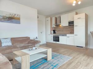 a living room with a couch and a coffee table at Nr 57 - Ferienwohnung Mühlenstraße in Carolinensiel +17 photos
