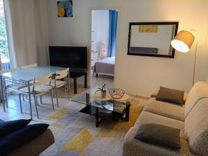 a living room with a couch and a table at Villa au Cœur du Centre - Jardin & Terrasse, Parking Gratuit in Aix-en-Provence
