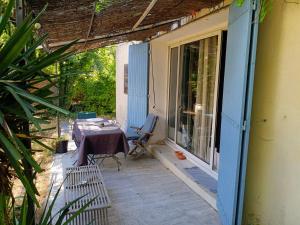 a patio with a table and a chair on a porch at Villa au Cœur du Centre - Jardin & Terrasse, Parking Gratuit in Aix-en-Provence