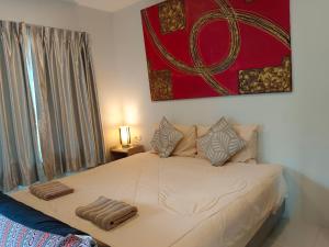 a bed with two pillows on it in a room at Na Na Twinhouse in Bang Tao Beach