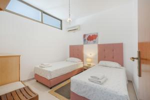 a small room with two beds and a window at Dorothy's Seaview Apartment in Haraki