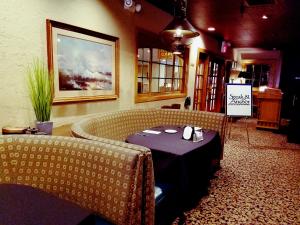 una habitación con una mesa y dos sofás y un cartel en Piccadilly Inn Airport en Fresno