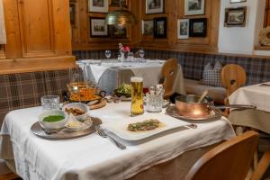 a table with plates of food and drinks on it at Hotel zum Hirschen Zell am See in Zell am See