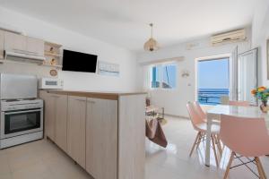 a kitchen and dining room with a table and a view of the ocean at Dorothy's Seaview Apartment in Haraki
