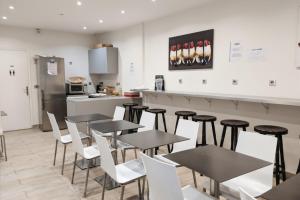 a restaurant with tables and chairs and a kitchen at Enjoy Hostel in Paris +10 photos