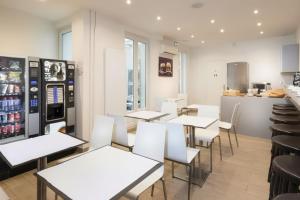 a restaurant with white tables and white chairs at Enjoy Hostel in Paris